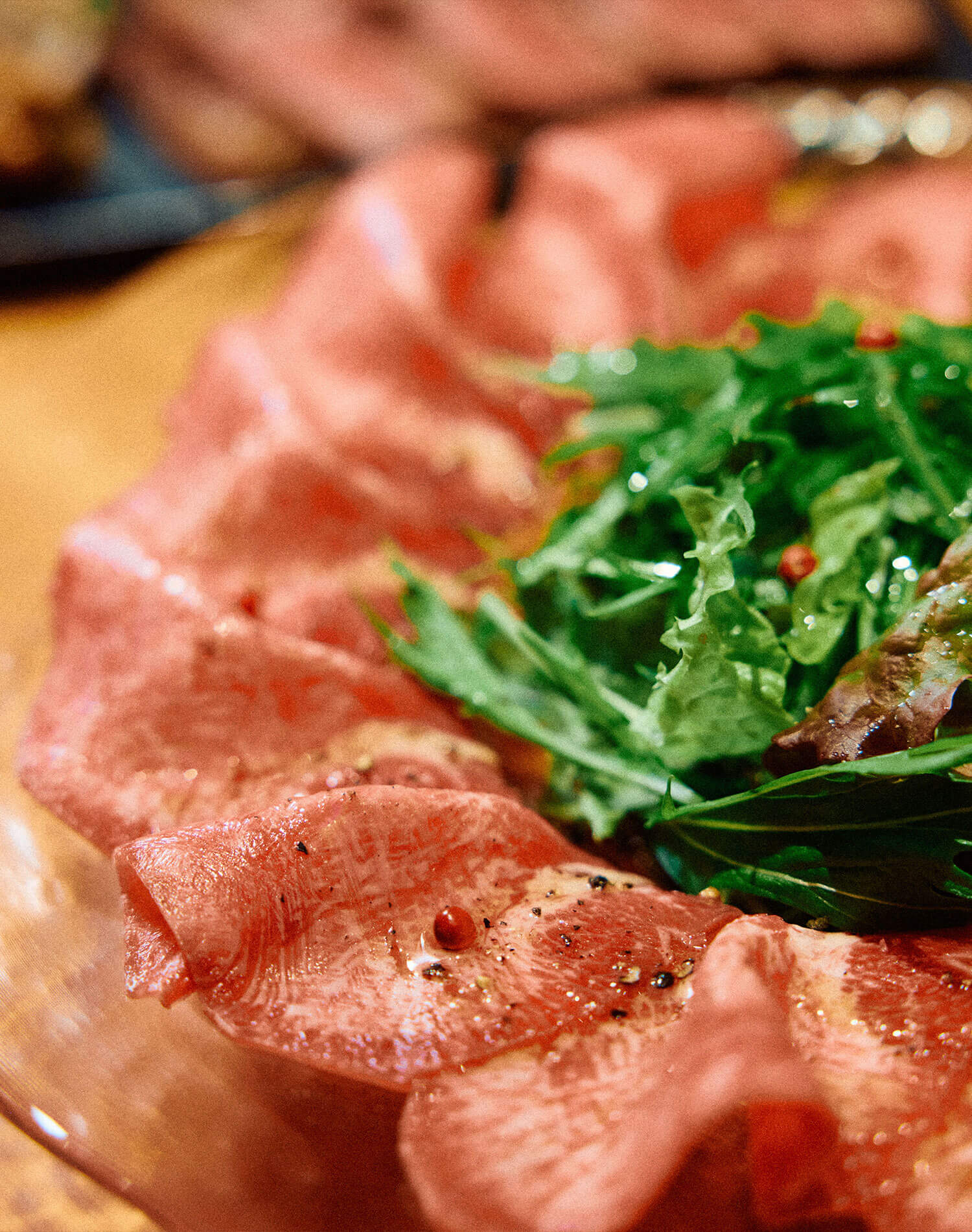 新鮮な薄切り牛タンをオリーブオイルでいただく〈牛タンカルパッチョ〉