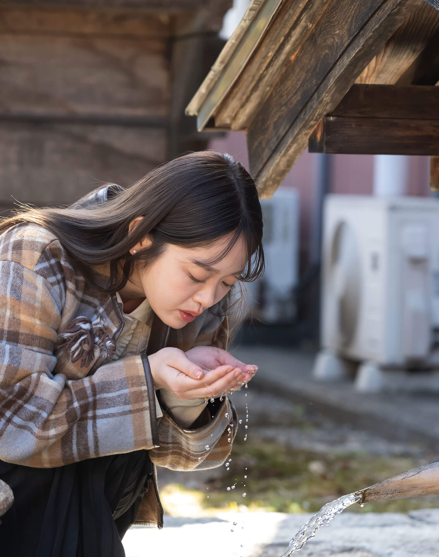 仕込み水を口に含む池田さん